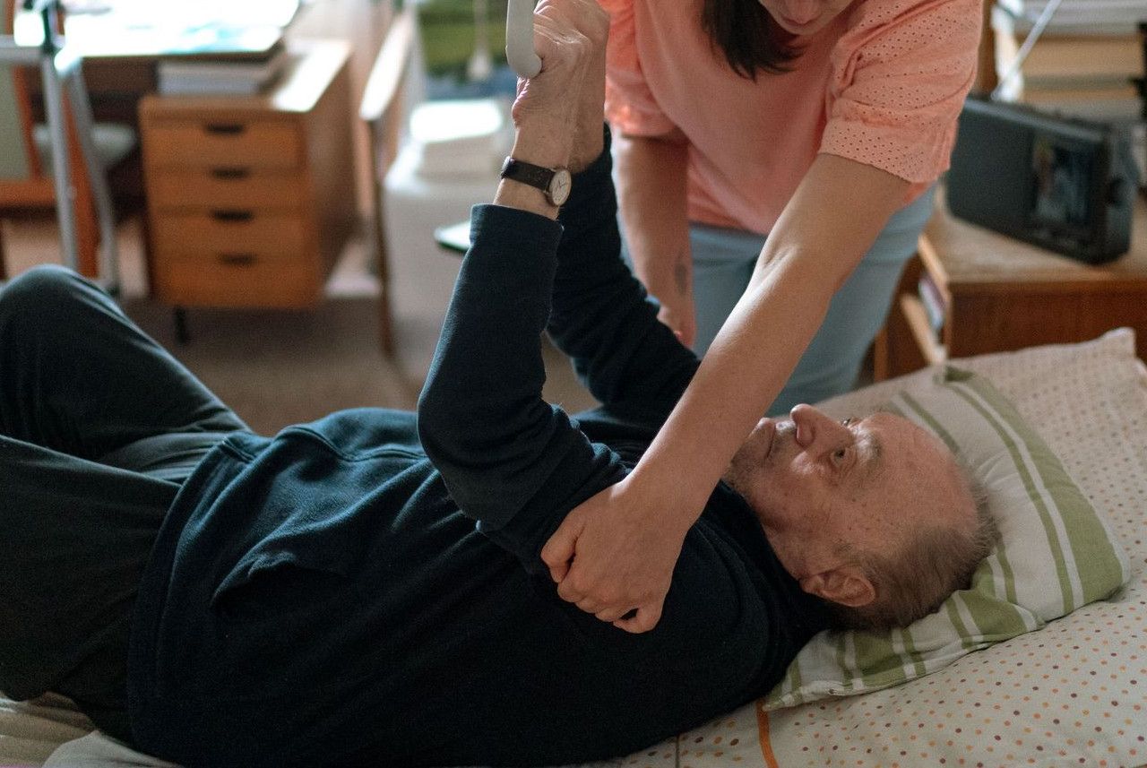 A caregiver assists an elderly man in a home environment, showcasing compassionate home care.